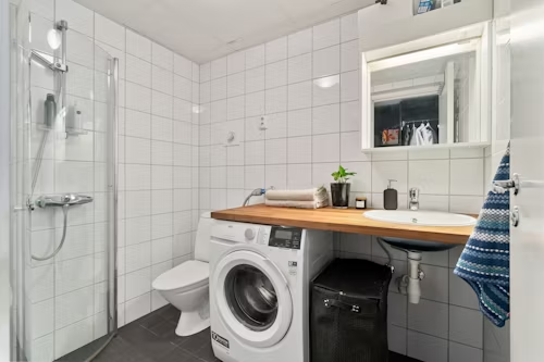 A small washroom area with dryer and bathroom accessories