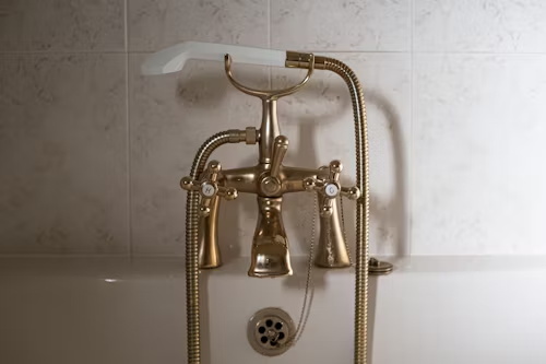 A gold bath faucet shower in the washroom