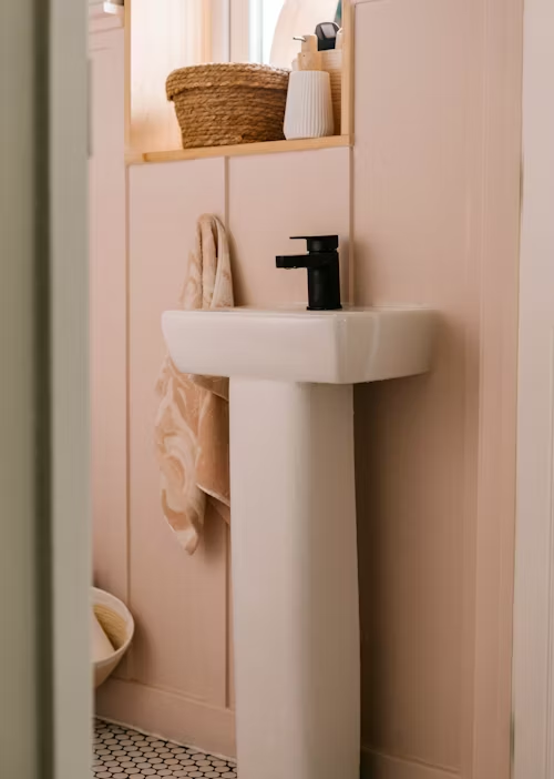A bathroom with sink and towel hanger brass faucets